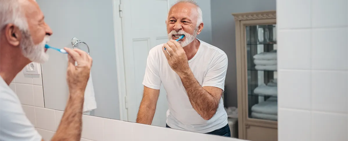 adulto mayor cepillándose los dientes