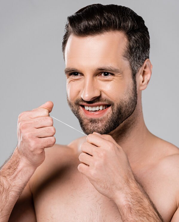 adulto en sus cuarentas usando hilo dental