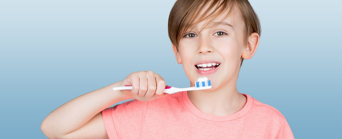 niño cepillánsose los dientes