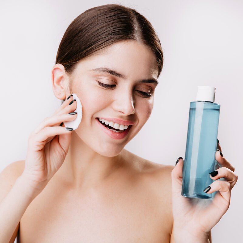 mujer sosteniendo tónico facial